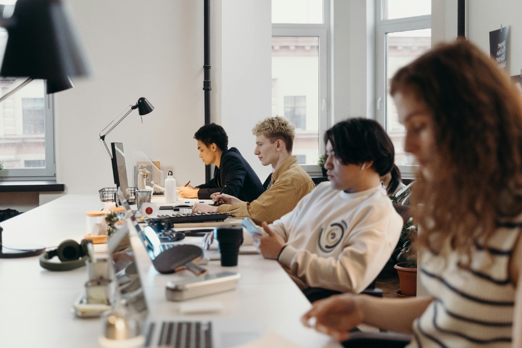 Professionnels au travail sur ordinateurs dans un bureau lumineux, conception d'automatisations et agents IA.