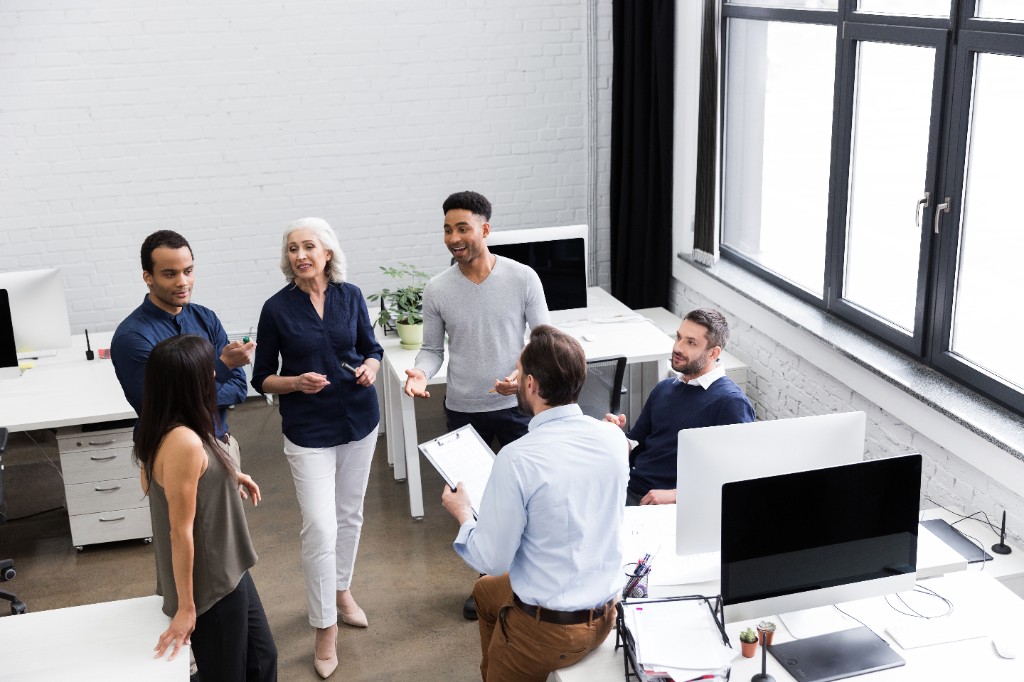 Équipe en réunion dans un bureau moderne — collaboration et atelier pratique sur l’IA au travail.